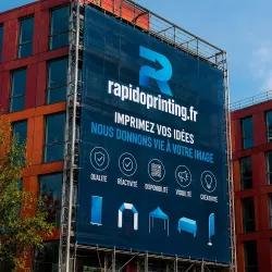 Bâche publicitaire personnalisée affichant des idées et logos sur grand format, installée sur façade d’immeuble.