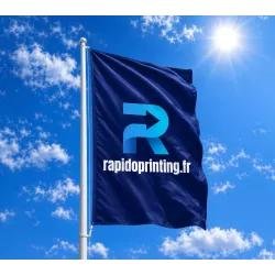 Drapeau publicitaire extérieur bleu avec logo et texte rapideprinting.fr, flottant au vent sous un ciel bleu.