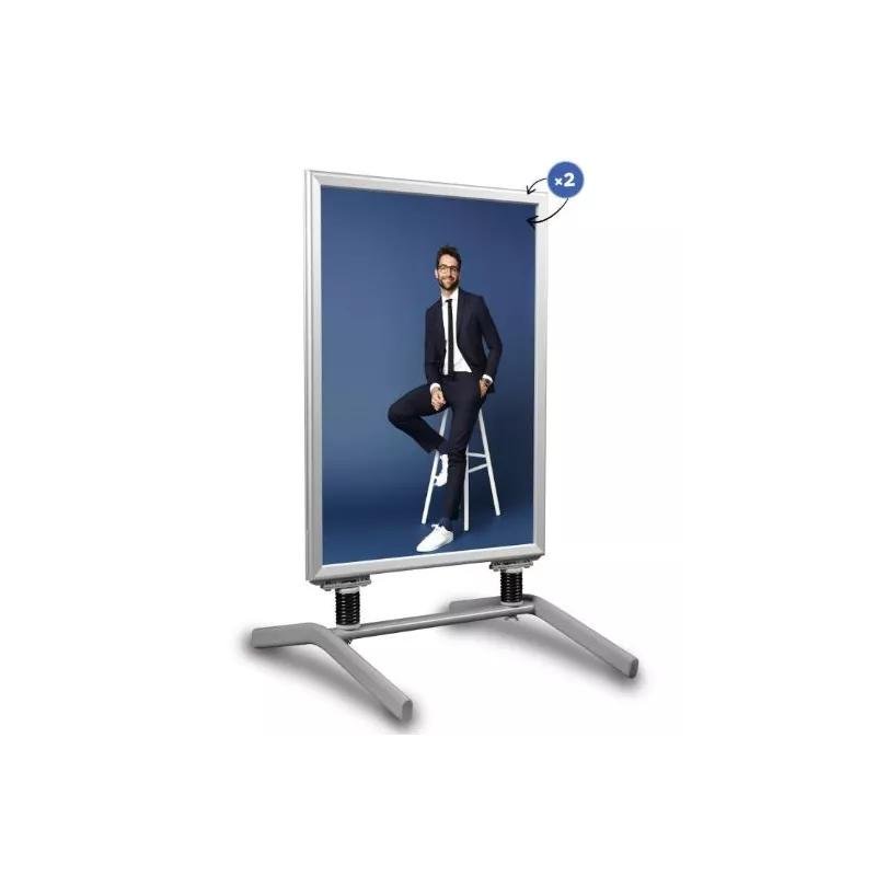 Panneau publicitaire vertical sur support métallique avec pieds en T et ressorts visibles.