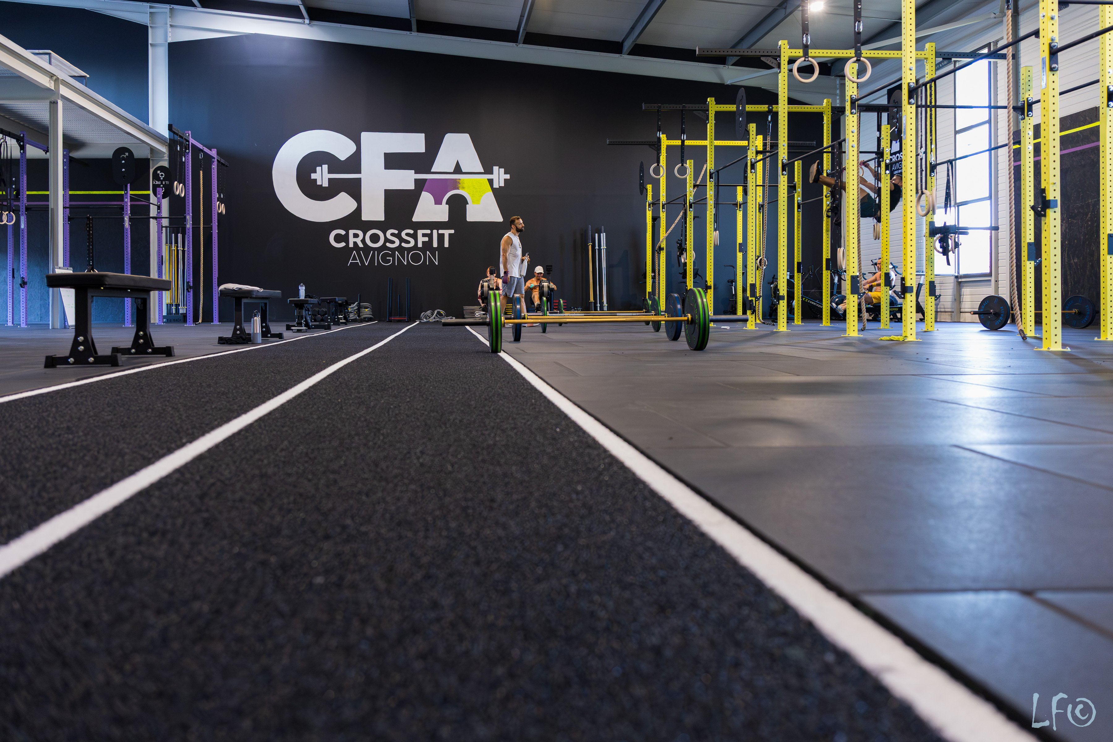 Salle de CrossFit avec façade “CFA Crossfit Avignon”, zones d’entraînement et matériel de musculation sur fond bleu.】
